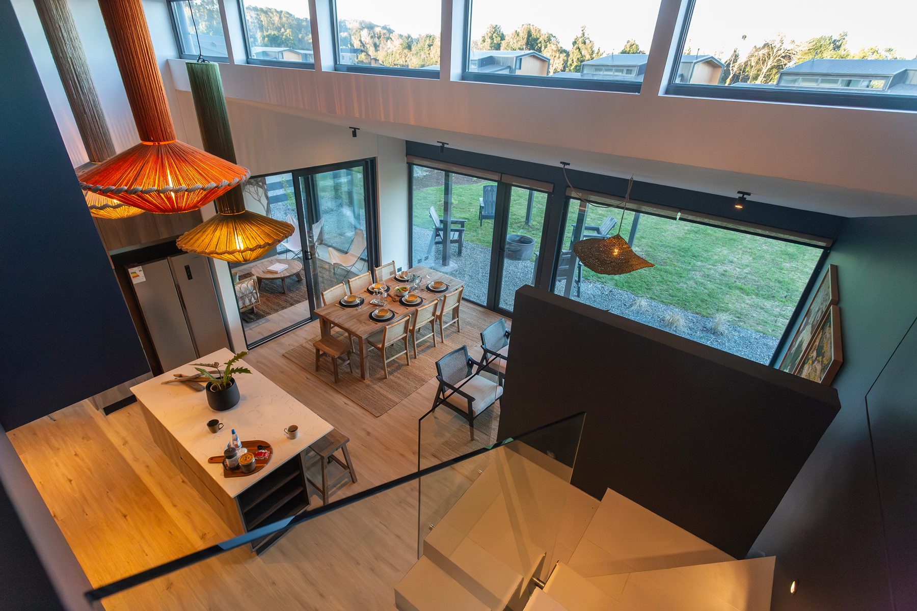 Interior de doble altura de una casa del condominio, con el comedor y el jardín