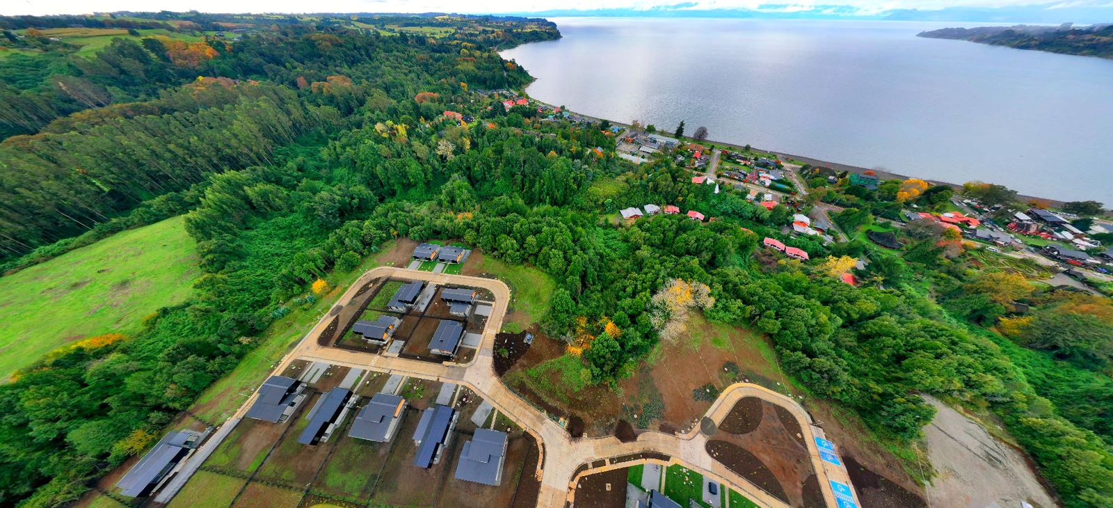 Condominio de casas rodeado de bosque, con el lago al fondo
